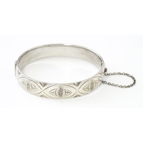 747 - A silver bracelet of bangle form with engraved decoration hallmarked 1963 maker Charles S Green & Co... 