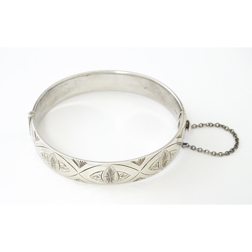 747 - A silver bracelet of bangle form with engraved decoration hallmarked 1963 maker Charles S Green & Co... 