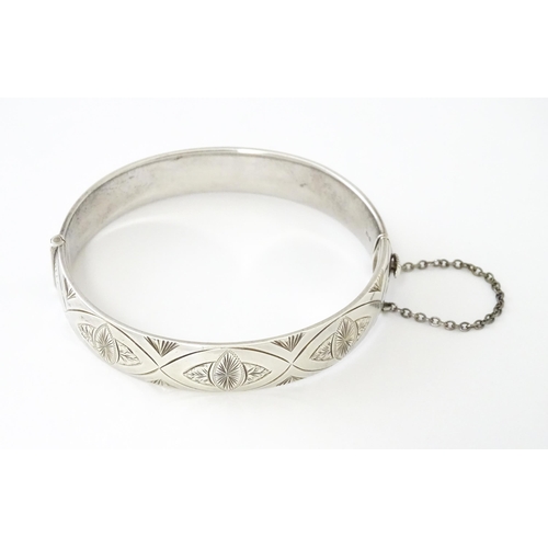 747 - A silver bracelet of bangle form with engraved decoration hallmarked 1963 maker Charles S Green & Co... 