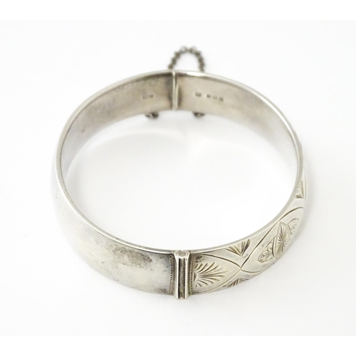 747 - A silver bracelet of bangle form with engraved decoration hallmarked 1963 maker Charles S Green & Co... 