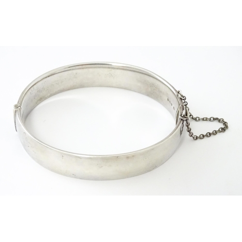 747 - A silver bracelet of bangle form with engraved decoration hallmarked 1963 maker Charles S Green & Co... 