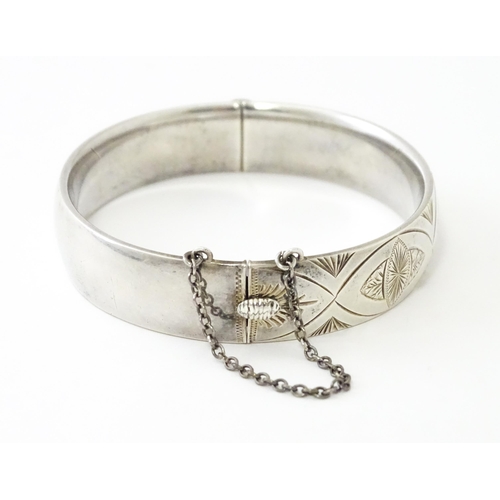 747 - A silver bracelet of bangle form with engraved decoration hallmarked 1963 maker Charles S Green & Co... 