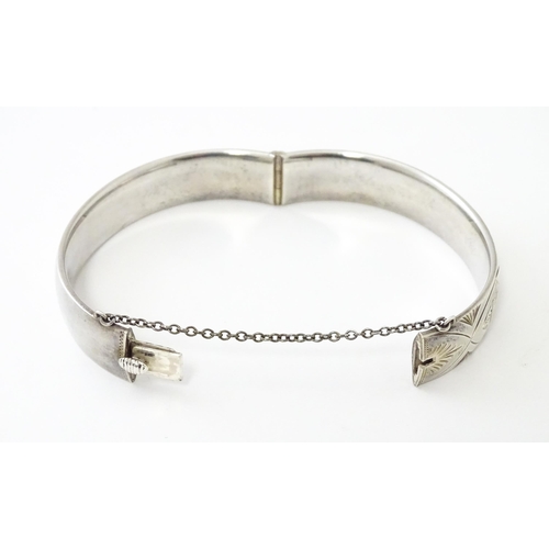 747 - A silver bracelet of bangle form with engraved decoration hallmarked 1963 maker Charles S Green & Co... 