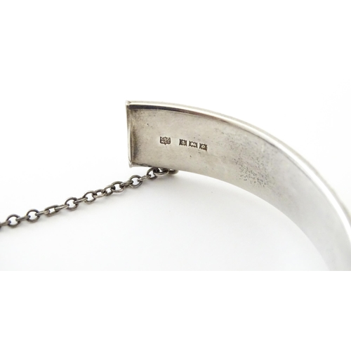 747 - A silver bracelet of bangle form with engraved decoration hallmarked 1963 maker Charles S Green & Co... 