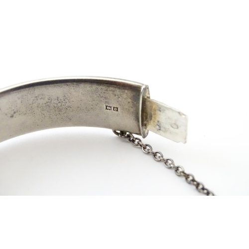 747 - A silver bracelet of bangle form with engraved decoration hallmarked 1963 maker Charles S Green & Co... 