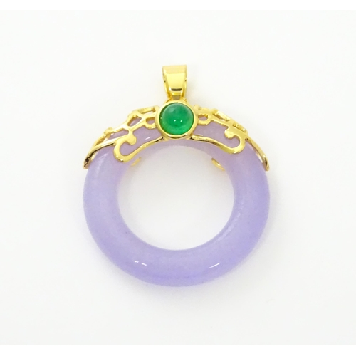 754 - A pendant with gilt metal mounts and purple coloured jade like ring detail. 1 1/2