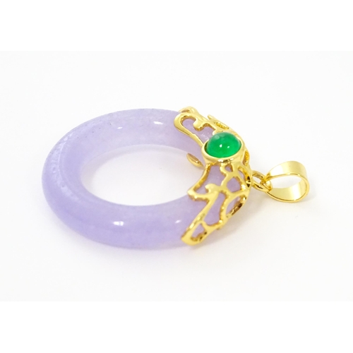 754 - A pendant with gilt metal mounts and purple coloured jade like ring detail. 1 1/2