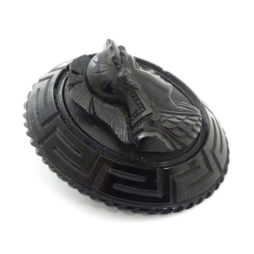 761 - A Victorian Whitby jet cameo brooch depicting the head of a Roman solider, within a Greek key mount.... 