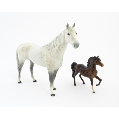 124 - A large Beswick dapple grey hunter horse. Together with a Beswick brown jogging mare. Marked under. ... 