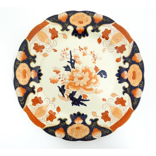 135 - A Derby plate decorated in the Imari palette with flowers and foliage. Together with two similar iro... 