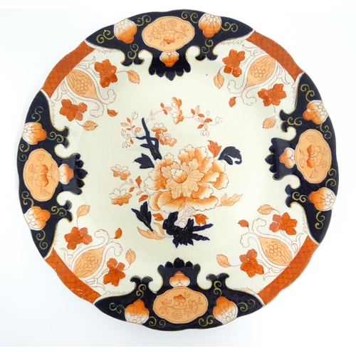 135 - A Derby plate decorated in the Imari palette with flowers and foliage. Together with two similar iro... 