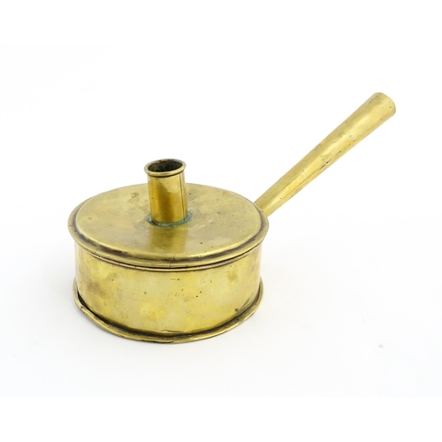 1074 - An 18th / 19thC brass tinder box with chamberstick / candle holder to lid, containing a flint and a ... 