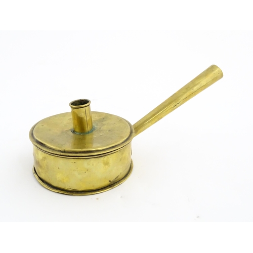 1074 - An 18th / 19thC brass tinder box with chamberstick / candle holder to lid, containing a flint and a ... 