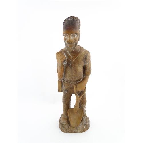 1131 - Ethnographic / Native / Tribal: An African carved wood figure modelled as a male farmer with a spade... 