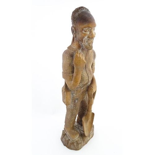 1131 - Ethnographic / Native / Tribal: An African carved wood figure modelled as a male farmer with a spade... 