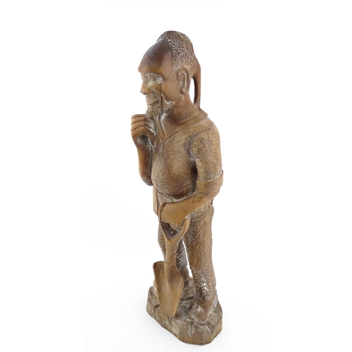 1131 - Ethnographic / Native / Tribal: An African carved wood figure modelled as a male farmer with a spade... 