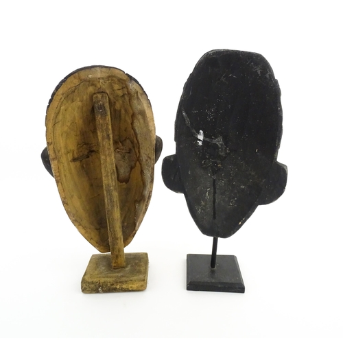 1132 - Ethnographic / Native / Tribal: Two African carved wooden masks with carved decoration, on with poly... 