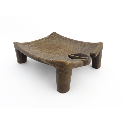 1135 - Ethnographic / Native / Tribal: An African carved wooden stool with pierced decoration, raised on fo... 