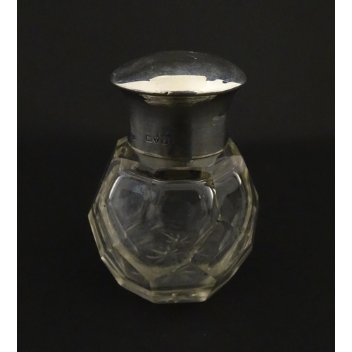 191 - A cut glass scent / perfume bottle with silver top hallmarked Chester 1912. Approx. 2 3/4