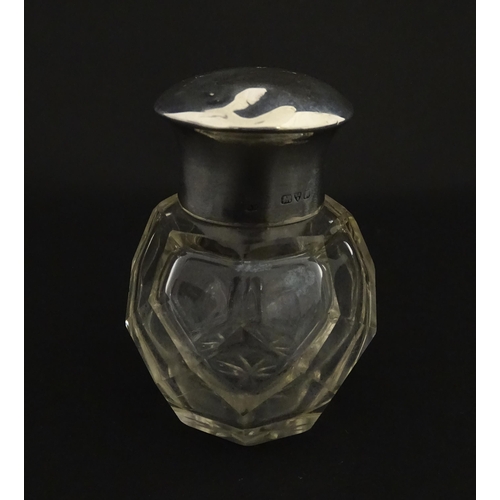 191 - A cut glass scent / perfume bottle with silver top hallmarked Chester 1912. Approx. 2 3/4