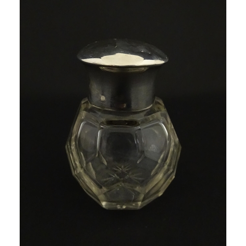 191 - A cut glass scent / perfume bottle with silver top hallmarked Chester 1912. Approx. 2 3/4