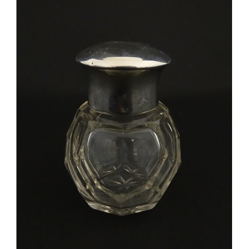 191 - A cut glass scent / perfume bottle with silver top hallmarked Chester 1912. Approx. 2 3/4