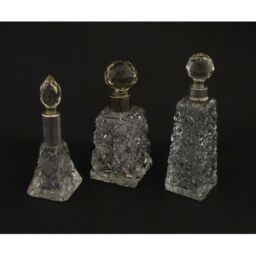 195A - Three assorted cut glass scent / perfume bottles with silver mounts, to include one hallmarked Birmi... 