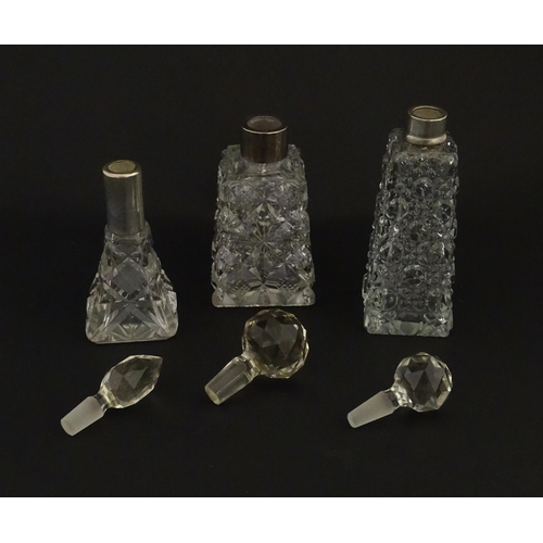 195A - Three assorted cut glass scent / perfume bottles with silver mounts, to include one hallmarked Birmi... 