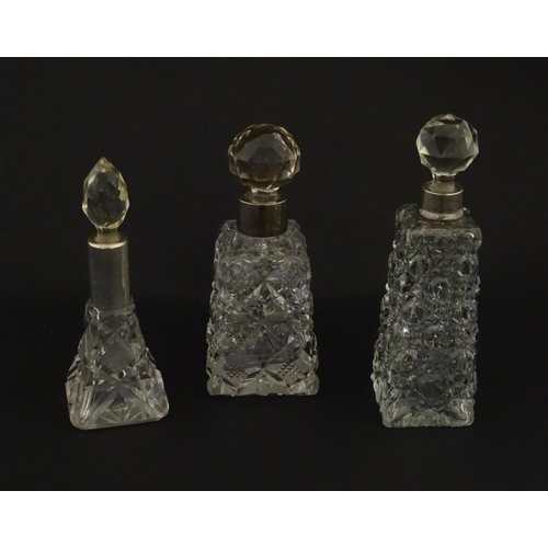 195A - Three assorted cut glass scent / perfume bottles with silver mounts, to include one hallmarked Birmi... 