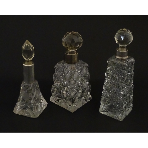 195A - Three assorted cut glass scent / perfume bottles with silver mounts, to include one hallmarked Birmi... 