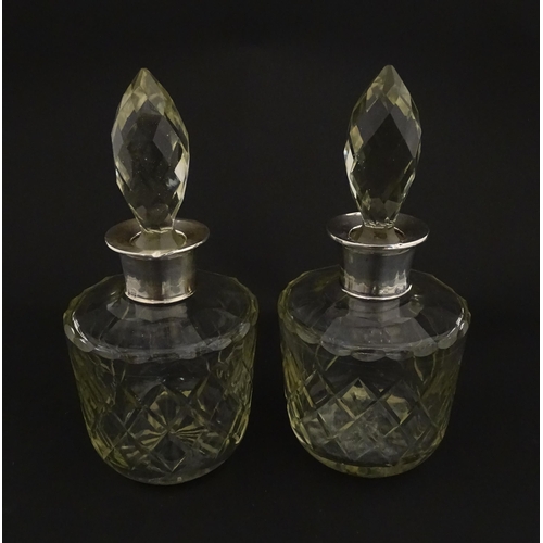 205 - Two glass flasks formed as small cut glass decanters with Argentinian .925 silver mounts. Approx. 8