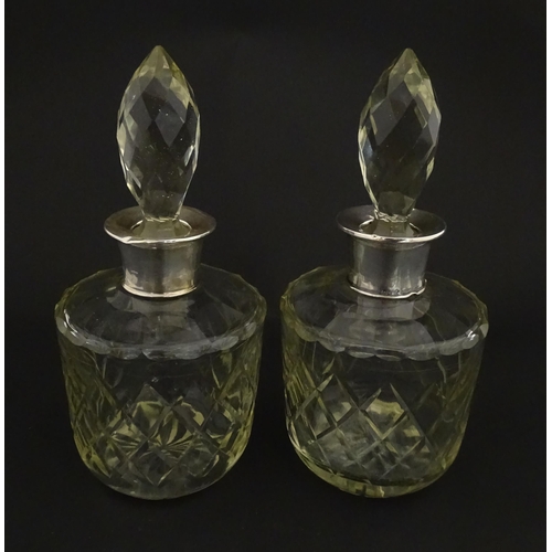 205 - Two glass flasks formed as small cut glass decanters with Argentinian .925 silver mounts. Approx. 8