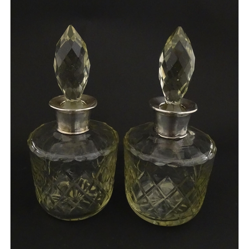 205 - Two glass flasks formed as small cut glass decanters with Argentinian .925 silver mounts. Approx. 8