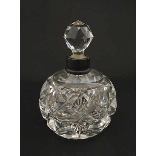 223 - A cut glass scent / perfume bottle with silver top hallmarked London C.1933 . Approx. 5 1/4