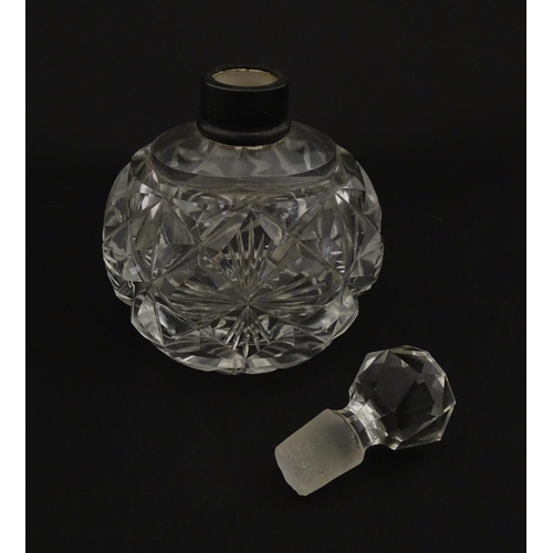 223 - A cut glass scent / perfume bottle with silver top hallmarked London C.1933 . Approx. 5 1/4