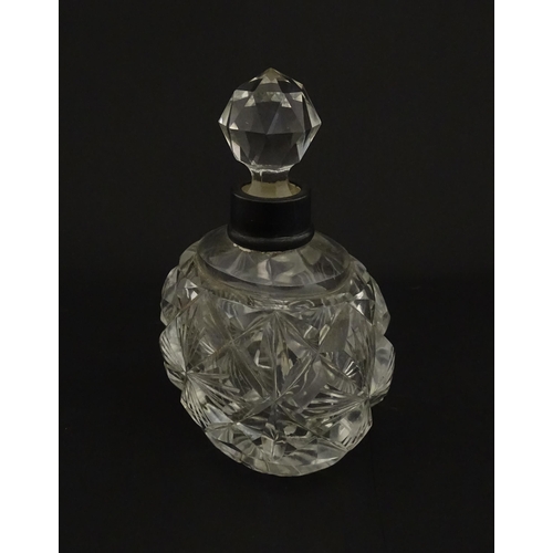 223 - A cut glass scent / perfume bottle with silver top hallmarked London C.1933 . Approx. 5 1/4