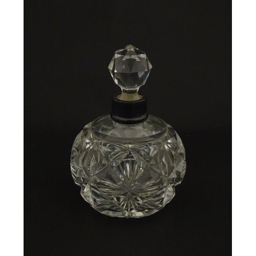 223 - A cut glass scent / perfume bottle with silver top hallmarked London C.1933 . Approx. 5 1/4