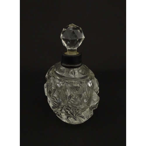 223 - A cut glass scent / perfume bottle with silver top hallmarked London C.1933 . Approx. 5 1/4