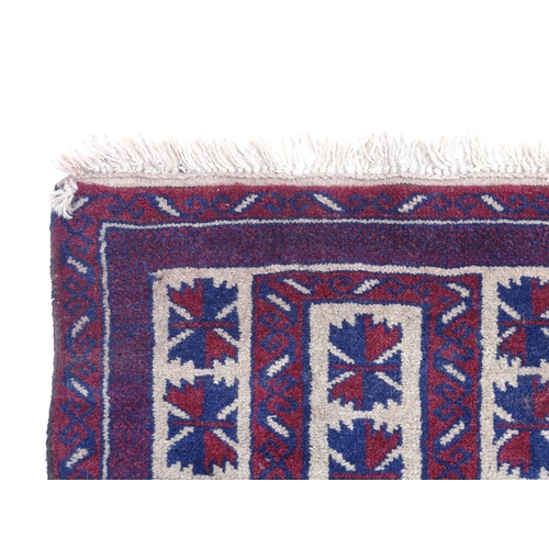 1369 - Carpet / Rug : A red, blue and cream ground rug with repeating geometric motifs. Approx. 55