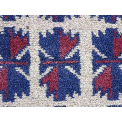 1369 - Carpet / Rug : A red, blue and cream ground rug with repeating geometric motifs. Approx. 55