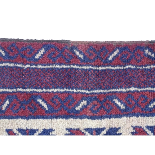 1369 - Carpet / Rug : A red, blue and cream ground rug with repeating geometric motifs. Approx. 55