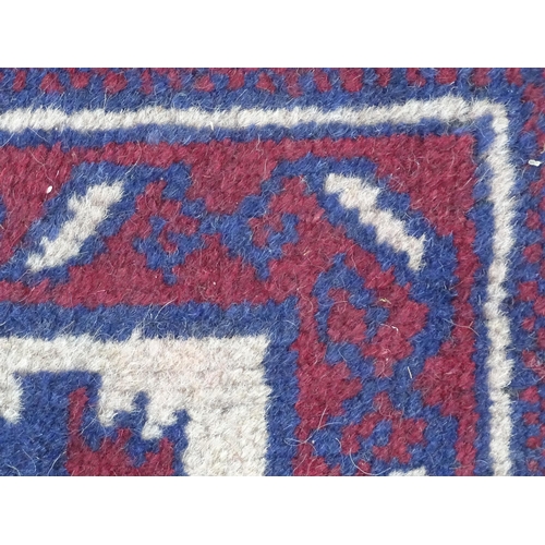 1369 - Carpet / Rug : A red, blue and cream ground rug with repeating geometric motifs. Approx. 55