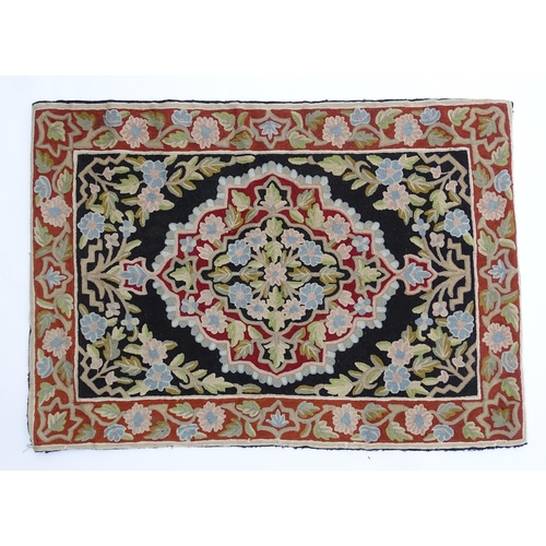 1371 - Carpet / Rug : A black and red ground rug with floral and foliate detail. Approx. 35