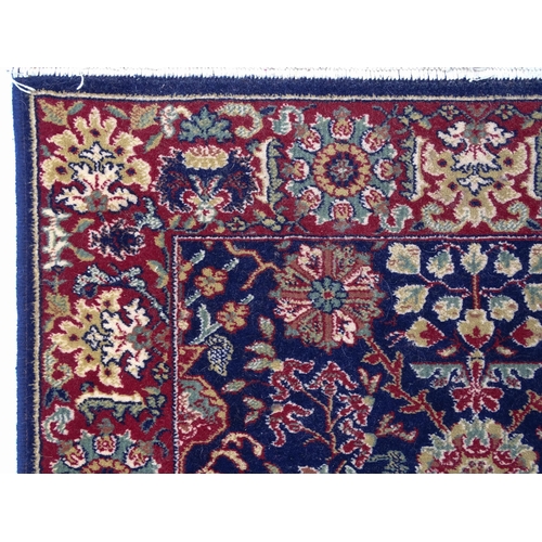 1375 - Carpet / Rug : A blue ground wool rug decorated with floral and foliate detail, further repeated to ... 