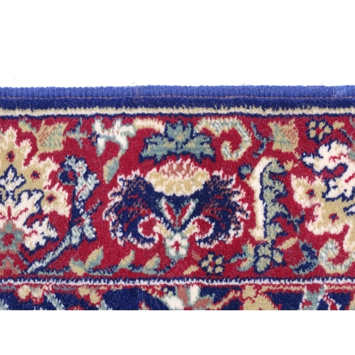 1375 - Carpet / Rug : A blue ground wool rug decorated with floral and foliate detail, further repeated to ... 