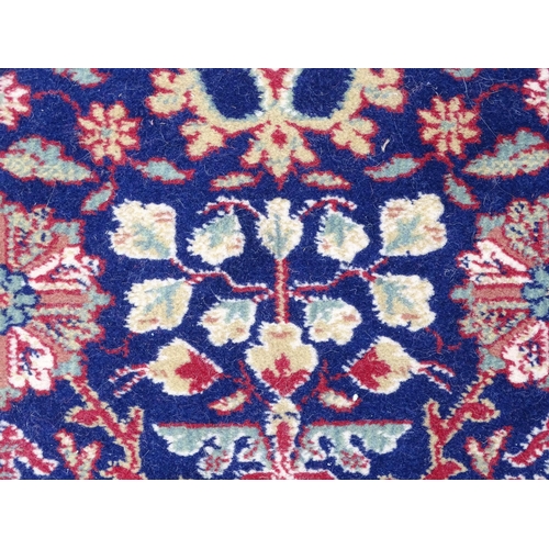 1375 - Carpet / Rug : A blue ground wool rug decorated with floral and foliate detail, further repeated to ... 