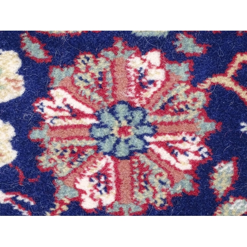 1375 - Carpet / Rug : A blue ground wool rug decorated with floral and foliate detail, further repeated to ... 