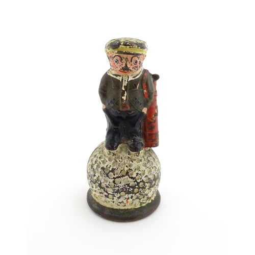 1160 - A 20thC Dunlop advertising table bell modelled as a golfer standing upon a golf ball, with polychrom... 