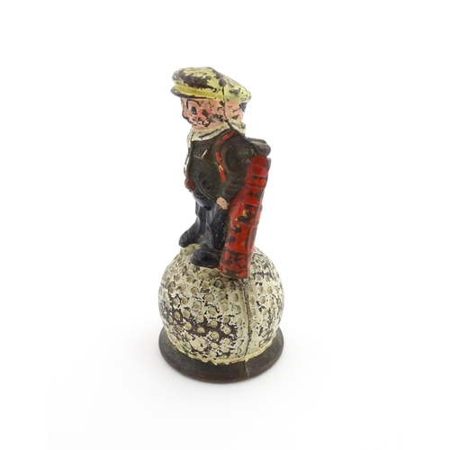 1160 - A 20thC Dunlop advertising table bell modelled as a golfer standing upon a golf ball, with polychrom... 