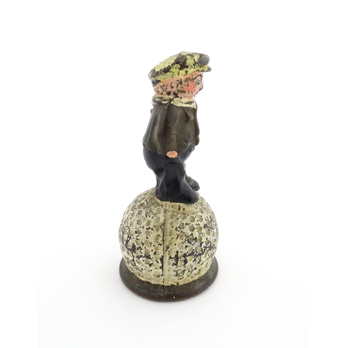 1160 - A 20thC Dunlop advertising table bell modelled as a golfer standing upon a golf ball, with polychrom... 